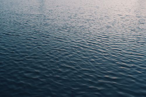 Free Serene view of rippling water surface during twilight, perfect for nature backgrounds. Stock Photo
