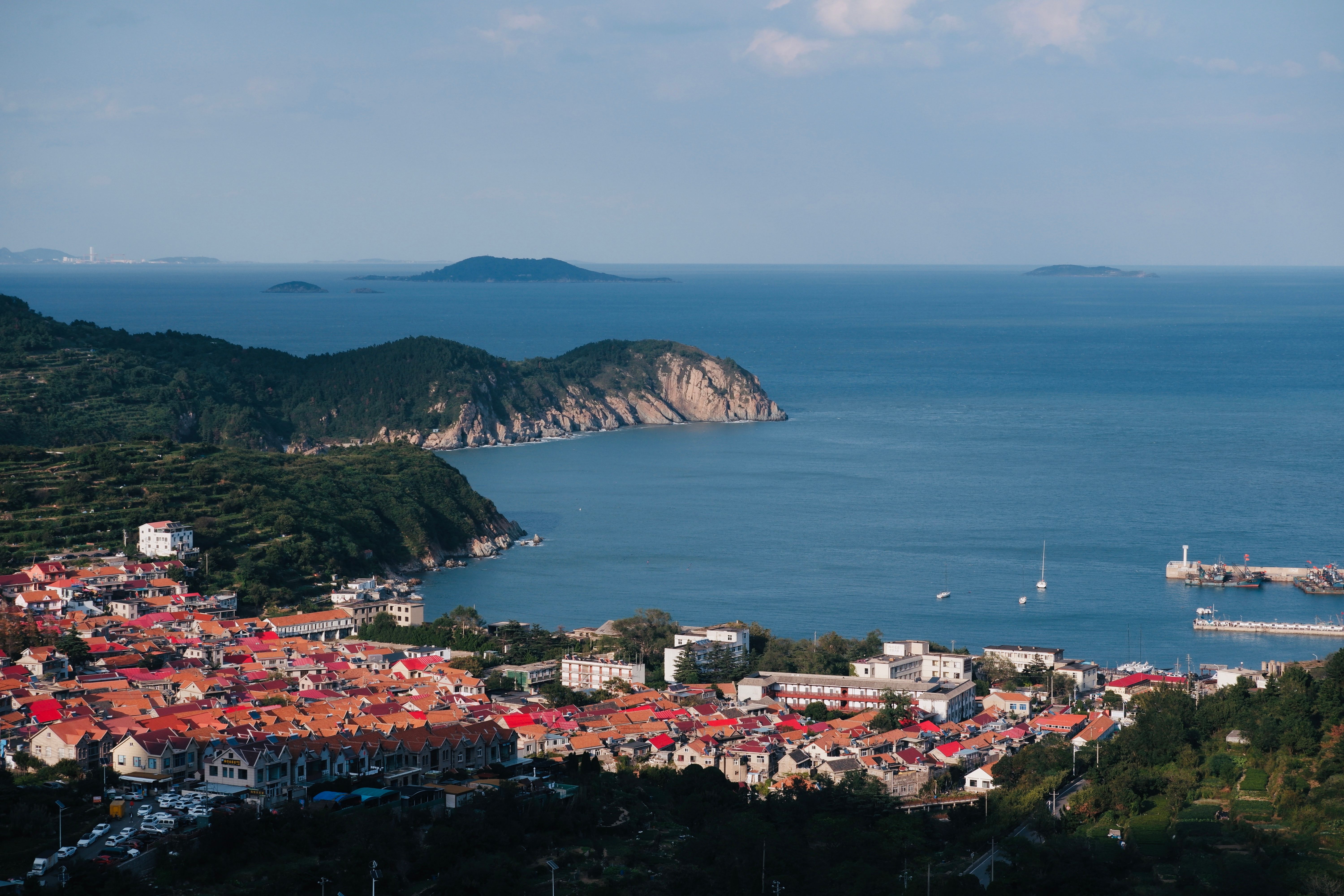 Scenic Coastal Town with Red Roofs and Ocean View · Free Stock Photo