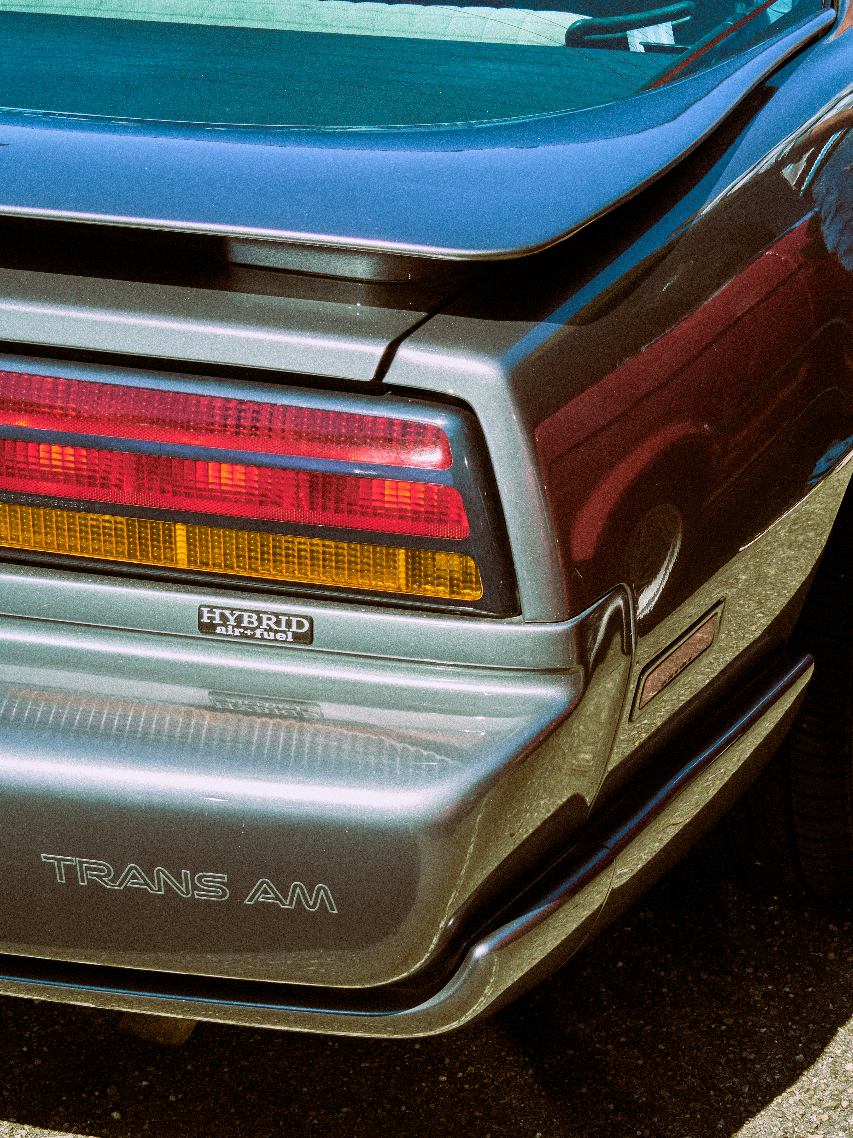 Close-up of a vintage Trans Am car tail light with hybrid air-fuel label.