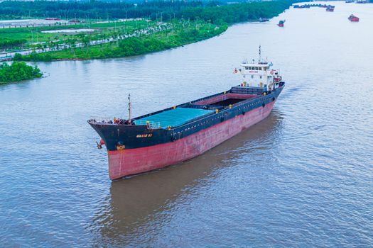 Aerial view of a cargo ship navigating the river in Hải Phòng, Vietnam.