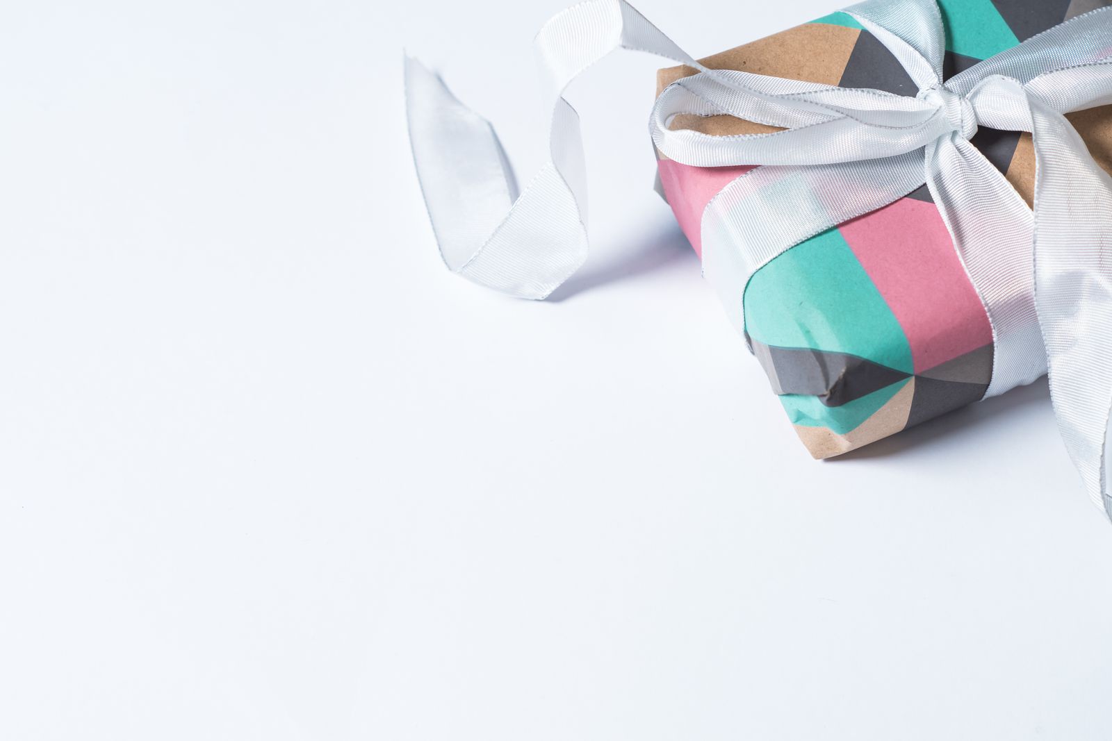 A colorful gift box wrapped with white ribbon, perfect for celebrations and holidays.