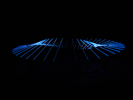 A captivating abstract blue light sculpture glows against a black background.