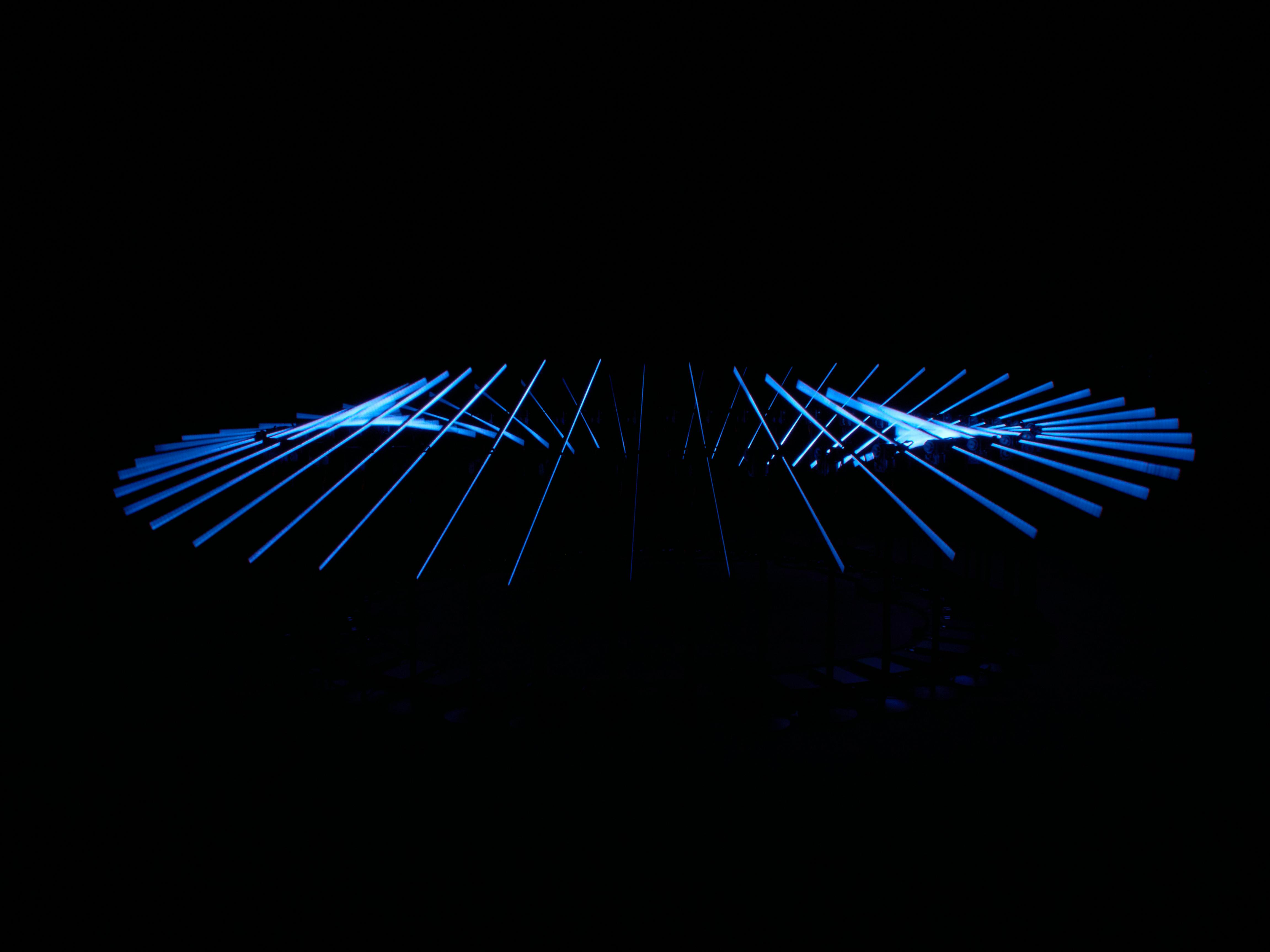 grátis Uma cativante escultura abstrata de luz azul brilha contra um fundo preto. Foto profissional