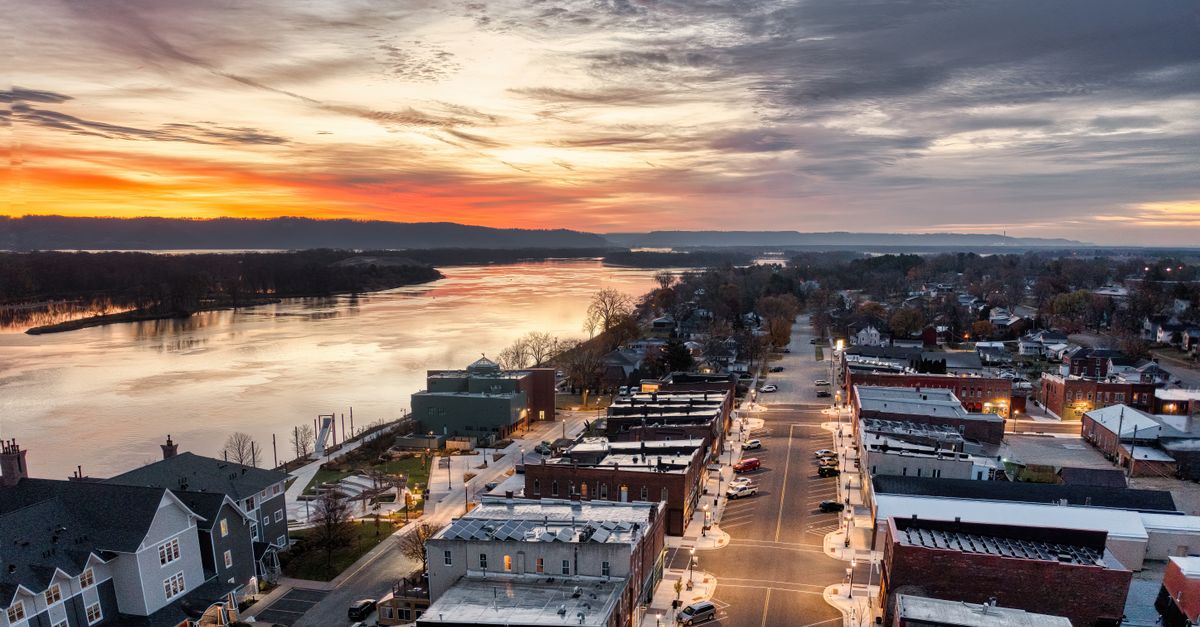 Aerial view of Wabasha, Minnesota at sunset showcasing streets, buildings, and the Mississippi River.