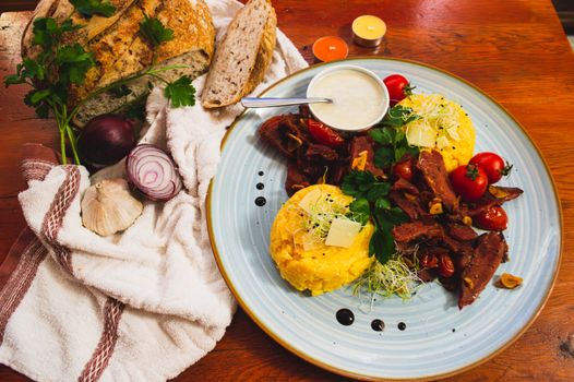 Delicious Romanian cuisine featuring polenta, vegetables, and artisan bread in a vibrant setting.