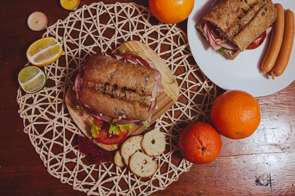 Photo by Costin Cerednicenco on Pexels Top view of a gourmet sandwich with citrus fruits and sausages, perfect for an outdoor brunch. - Photo by Costin Cerednicenco on Pexels