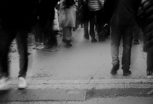 Free Blurred black and white image of people walking on a city street, capturing urban movement. Stock Photo
