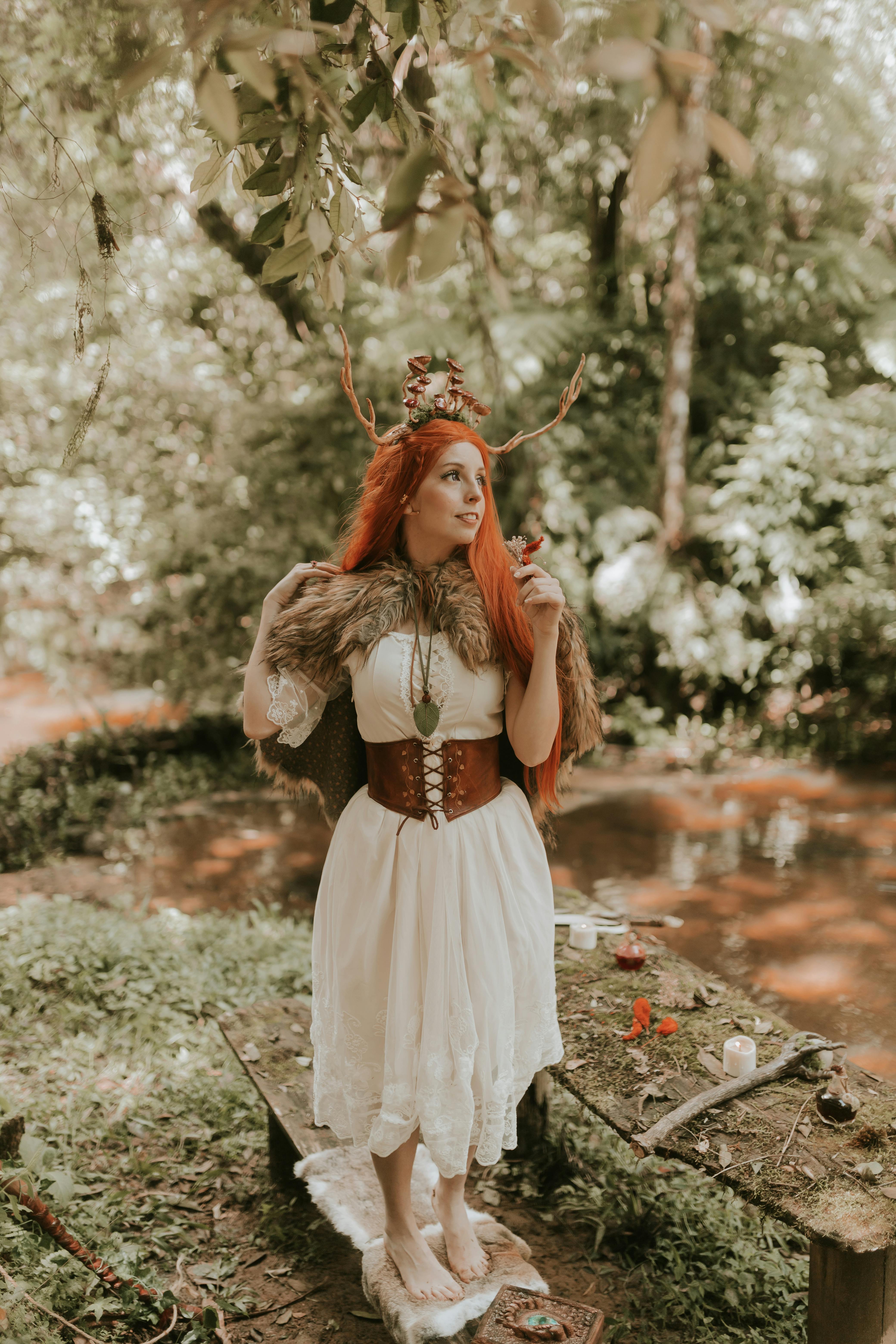 grátis Uma mulher mística fantasiada em meio a uma floresta exuberante, evocando fantasia e vibrações da natureza. Foto profissional