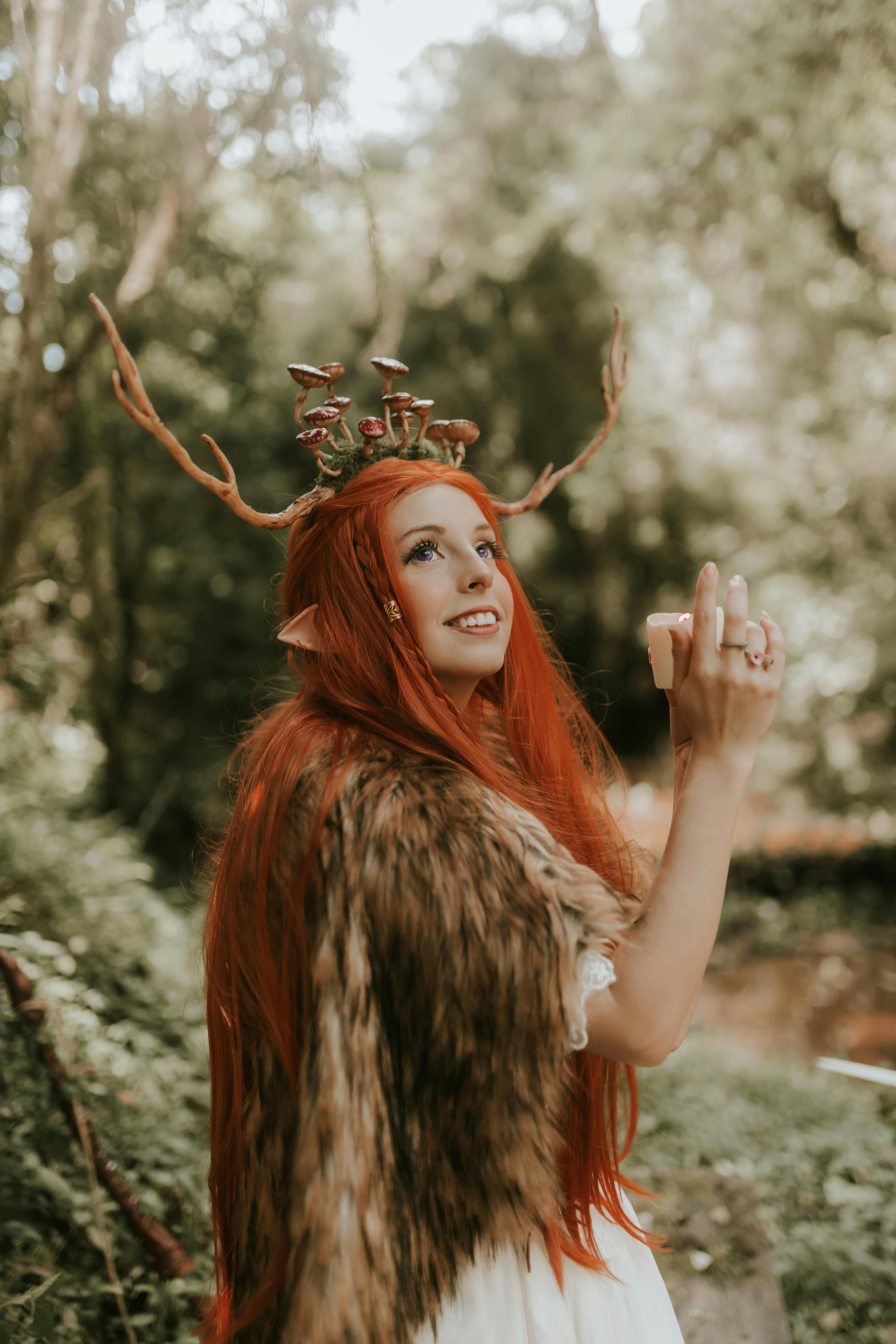 grátis Retrato fantástico de uma fada elfa ruiva em um cenário de floresta, exalando um charme caprichoso. Foto profissional
