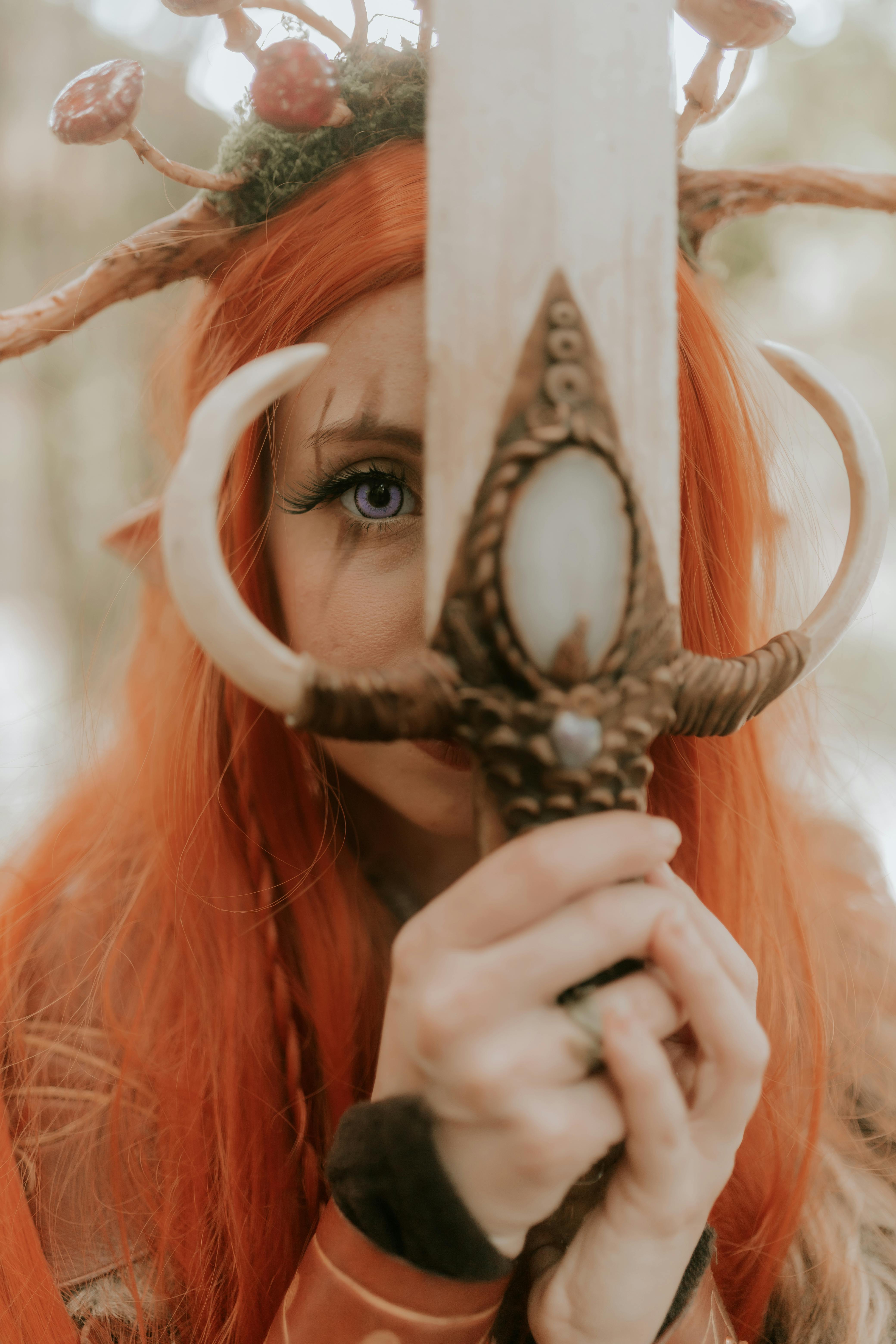 grátis Imagem cativante de uma guerreira elfa segurando uma espada mística em um cenário de floresta. Foto profissional