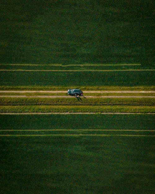 Vehicle On Road In The Middle Of Grass Field