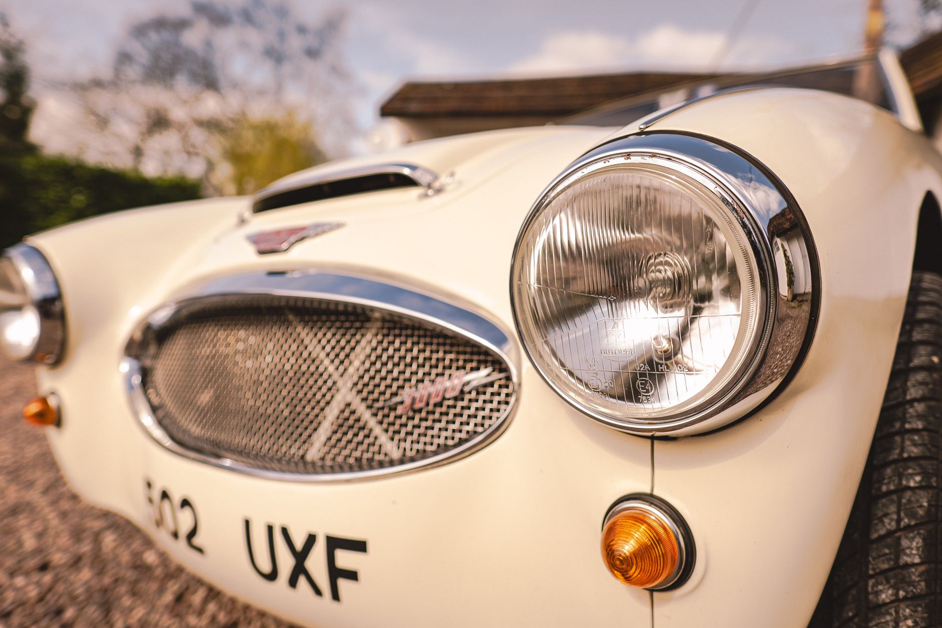 Detailed view of an Austin Healey car's headlight, showcasing its vintage charm.