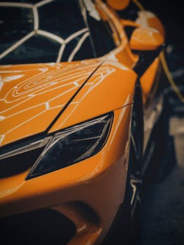 Detailed view of a sleek yellow sports car with glossy reflections captured in Berlin.