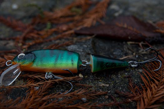Detailed shot of a green fishing lure resting on a ground with pine needles and leaves.
