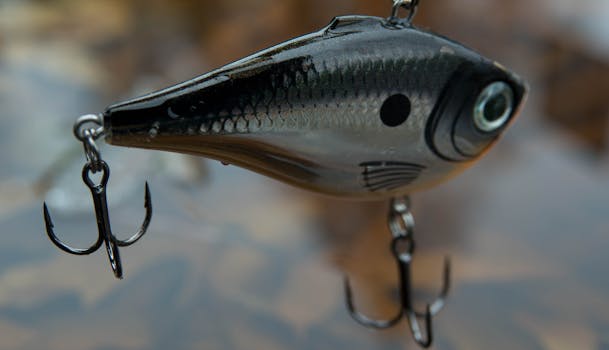 Detailed view of a shiny fish-shaped fishing lure above water surface.