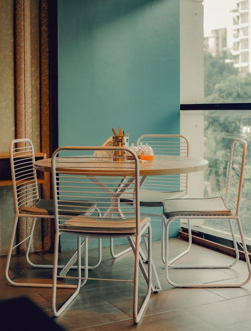Free Modern dining setup in a Chattogram room featuring elegant chairs and a round table. Stock Photo