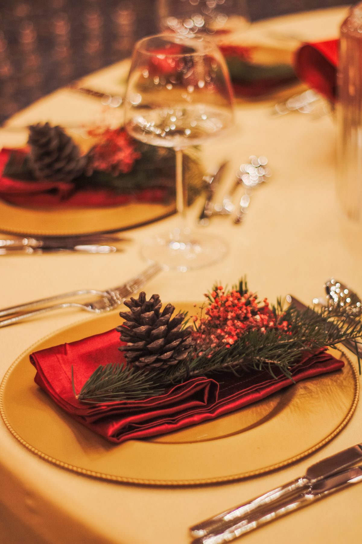 Mesa da ceia de Natal decorada Mesa de Natal posta com pinhas, guardanapos vermelhos e taças de cristal