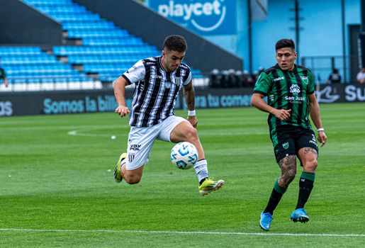 Intense football match moment with players in motion on the field.