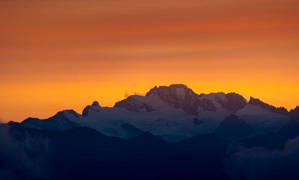Breathtaking sunset view of snow-capped peaks in Aosta Valley, Italy.