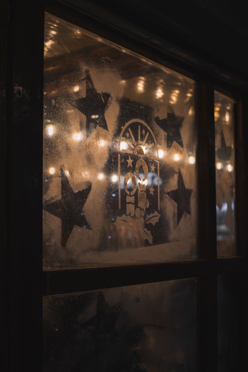 Free A cozy frosted window with star patterns and festive lights in Munich, Germany. Stock Photo