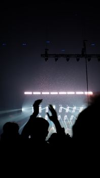 Silhouetted crowd with hands raised at a vibrant concert in Île-de-France, France.