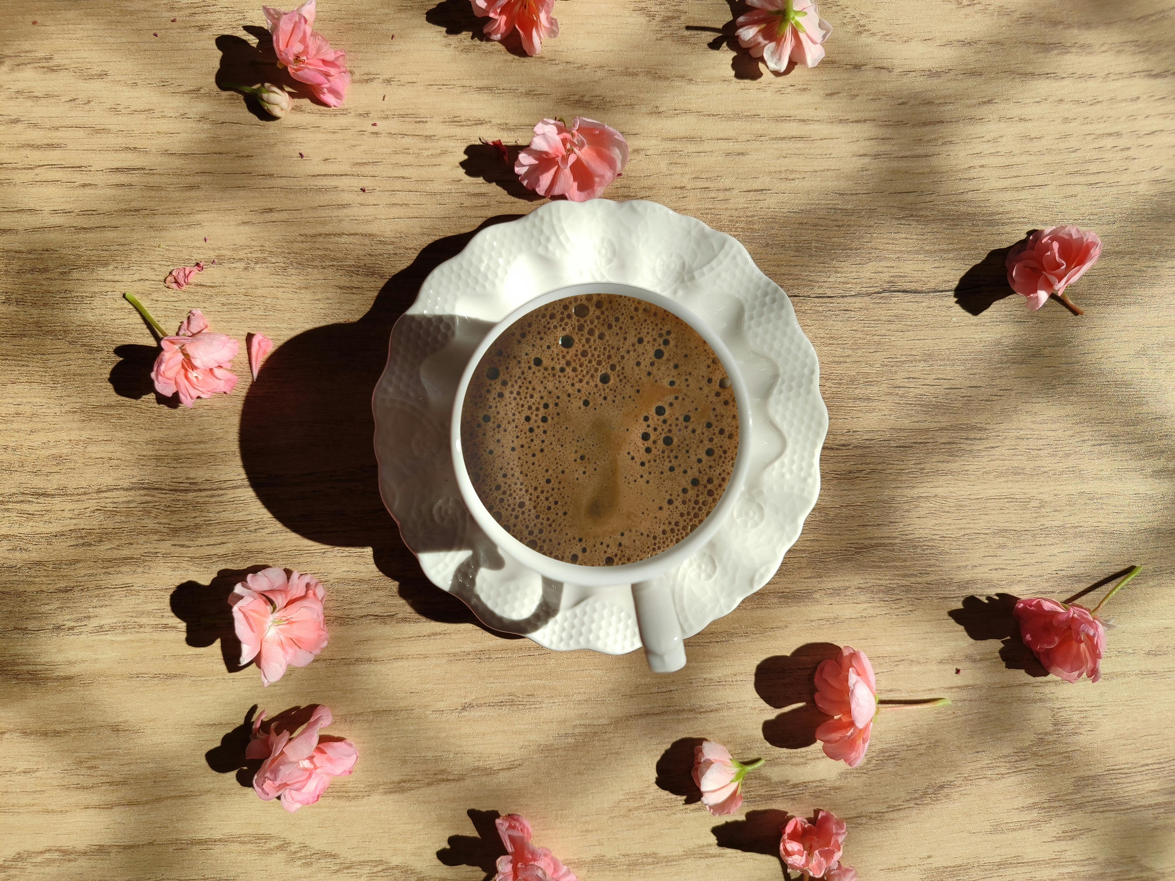 coffee cup with pink flowers on wooden table