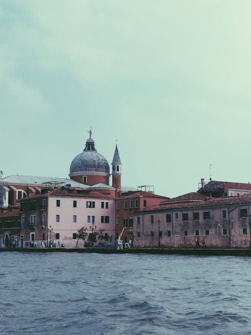 Brown Painted Buildings Across Body of Water