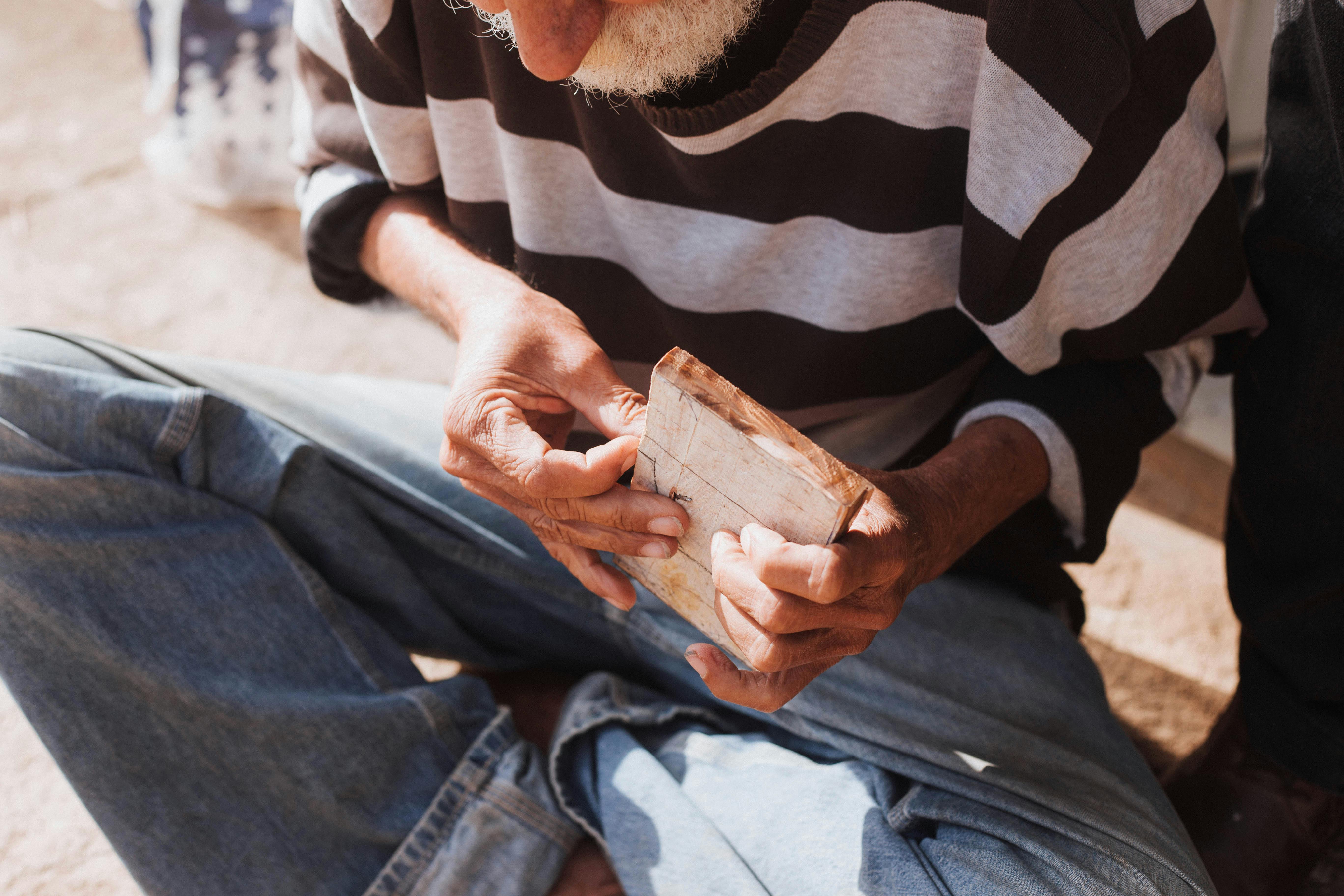 elderly artisan crafting wooden art piece