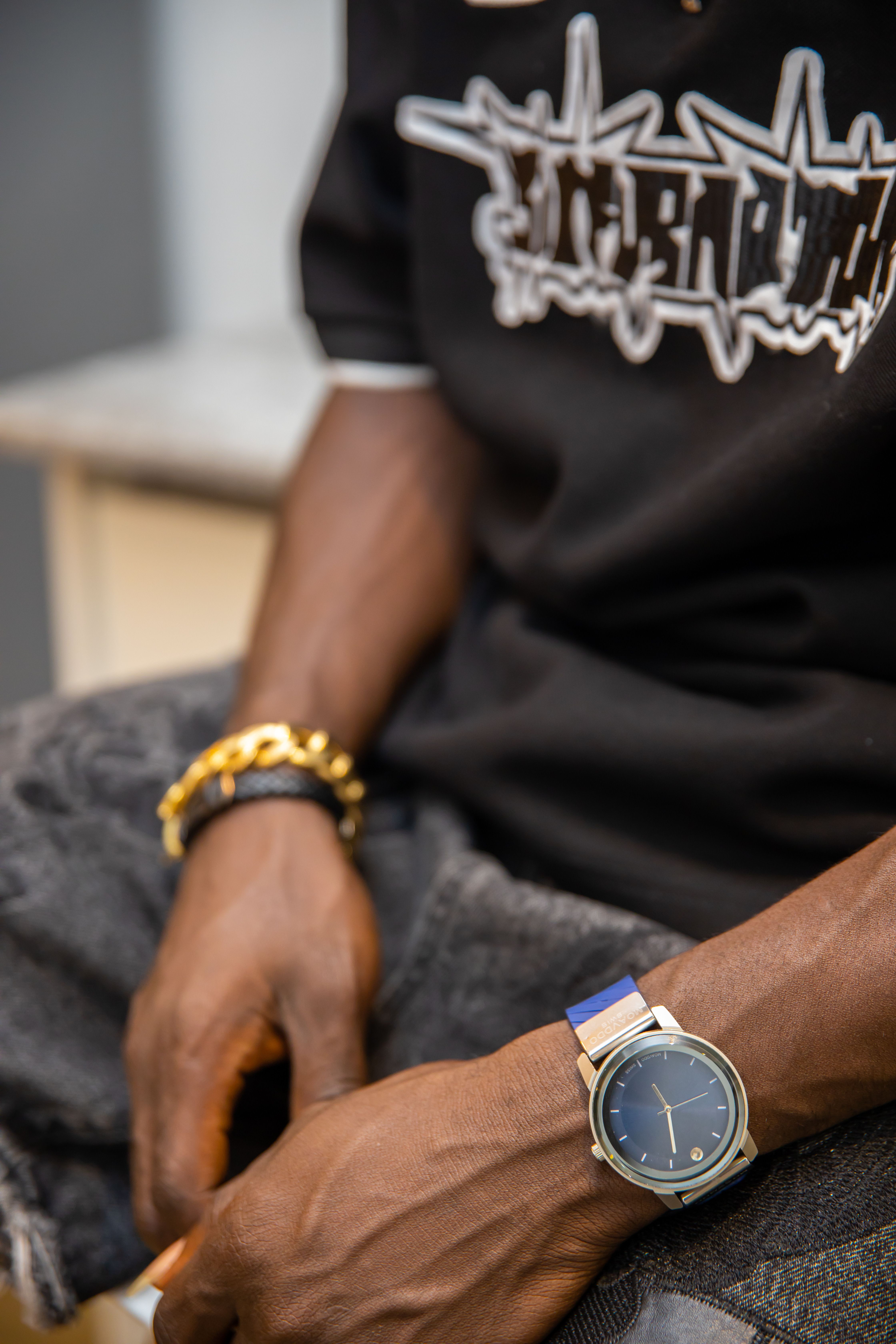 Close-up of a male wrist adorned with a stylish wristwatch and fashion bracelets, showcasing modern style.