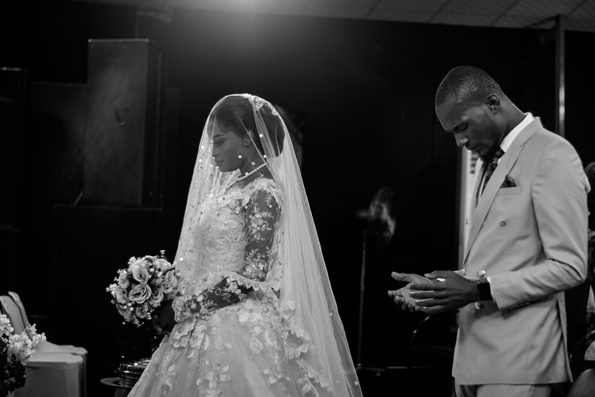 A black and white photo of a bride and groom during a wedding ceremony in Minna, Nigeria.