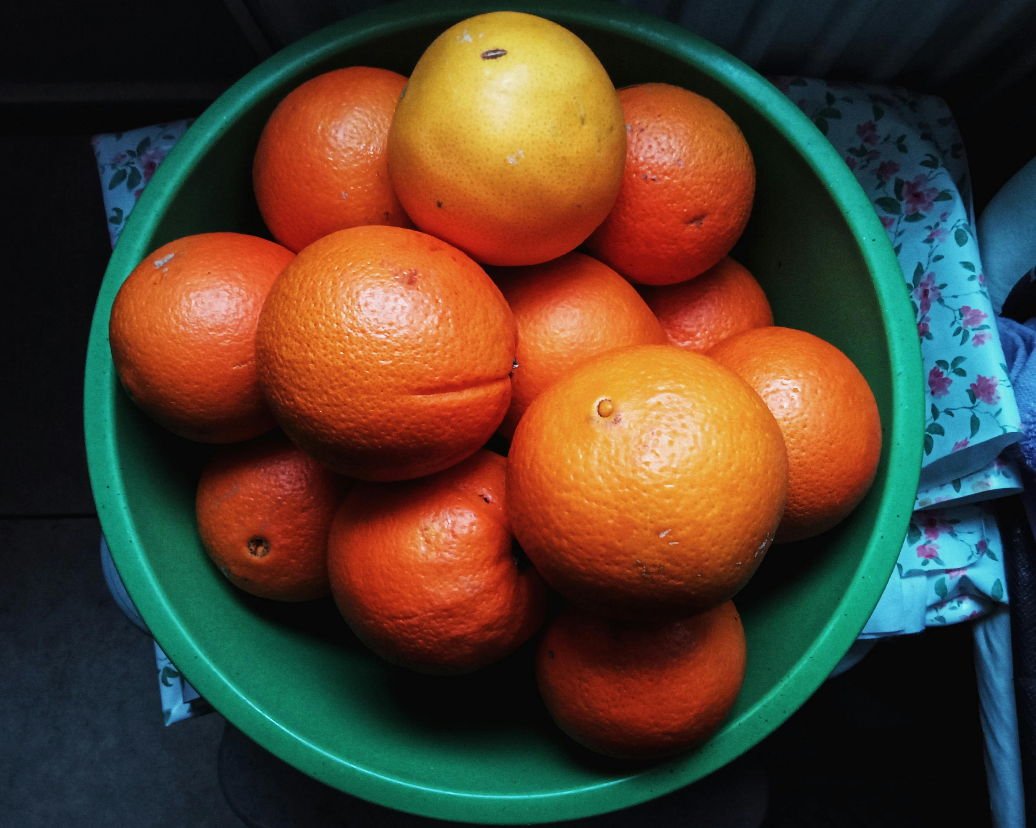 Bowl of oranges, kiwi, and peppers on a wooden table — vitamin C from food as a foundation