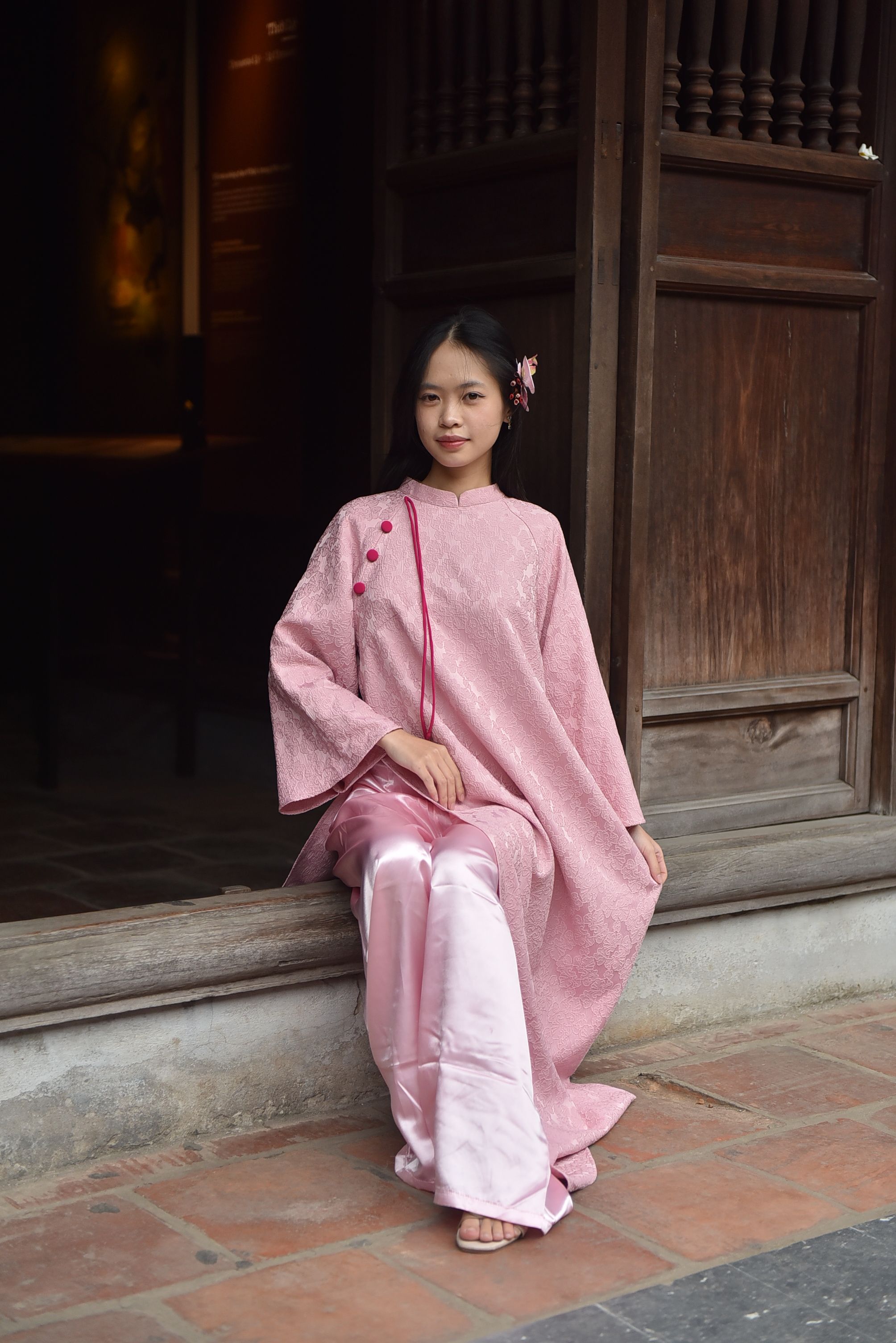 Elegant Woman in Traditional Pink Attire Sitting Indoors · Free Stock Photo