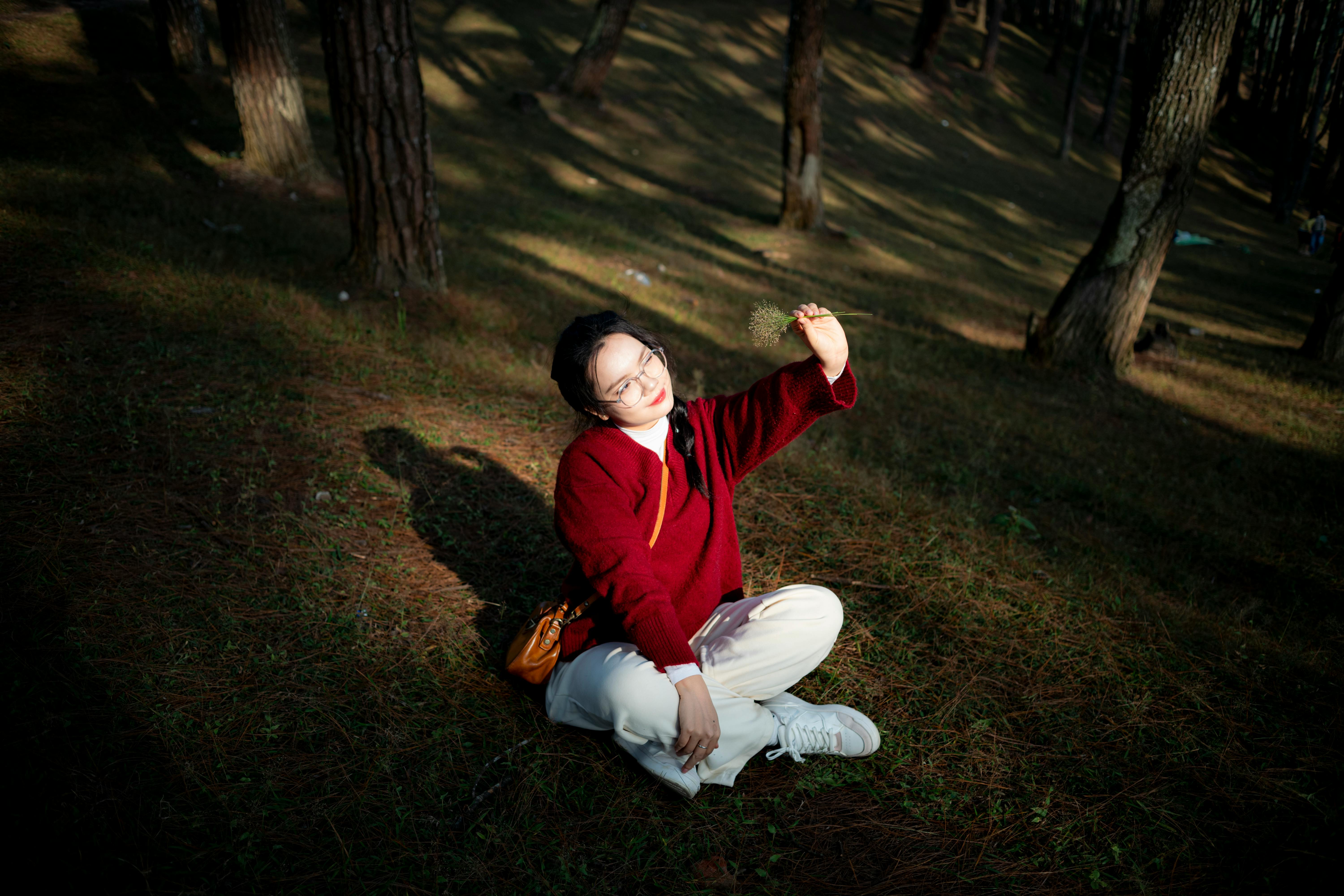 Peaceful moment of a woman in a forest in Hà Giang, Vietnam, holding a plant.