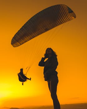 Silhouetted paragliding scene against a vibrant sunset sky in Kayseri, Türkiye.