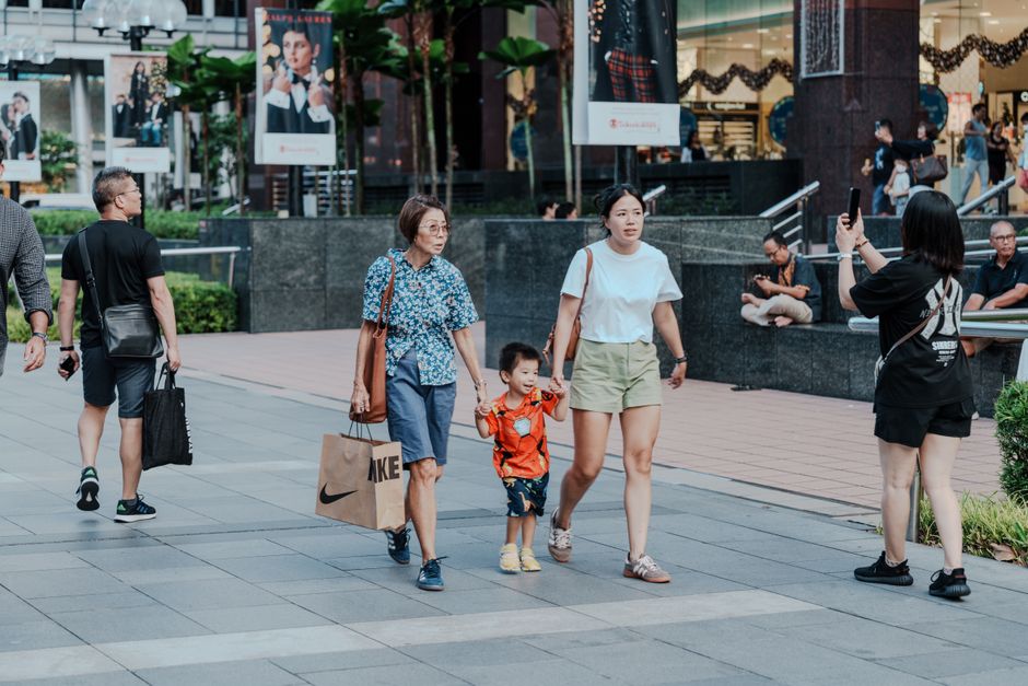 mother holding hands children mall