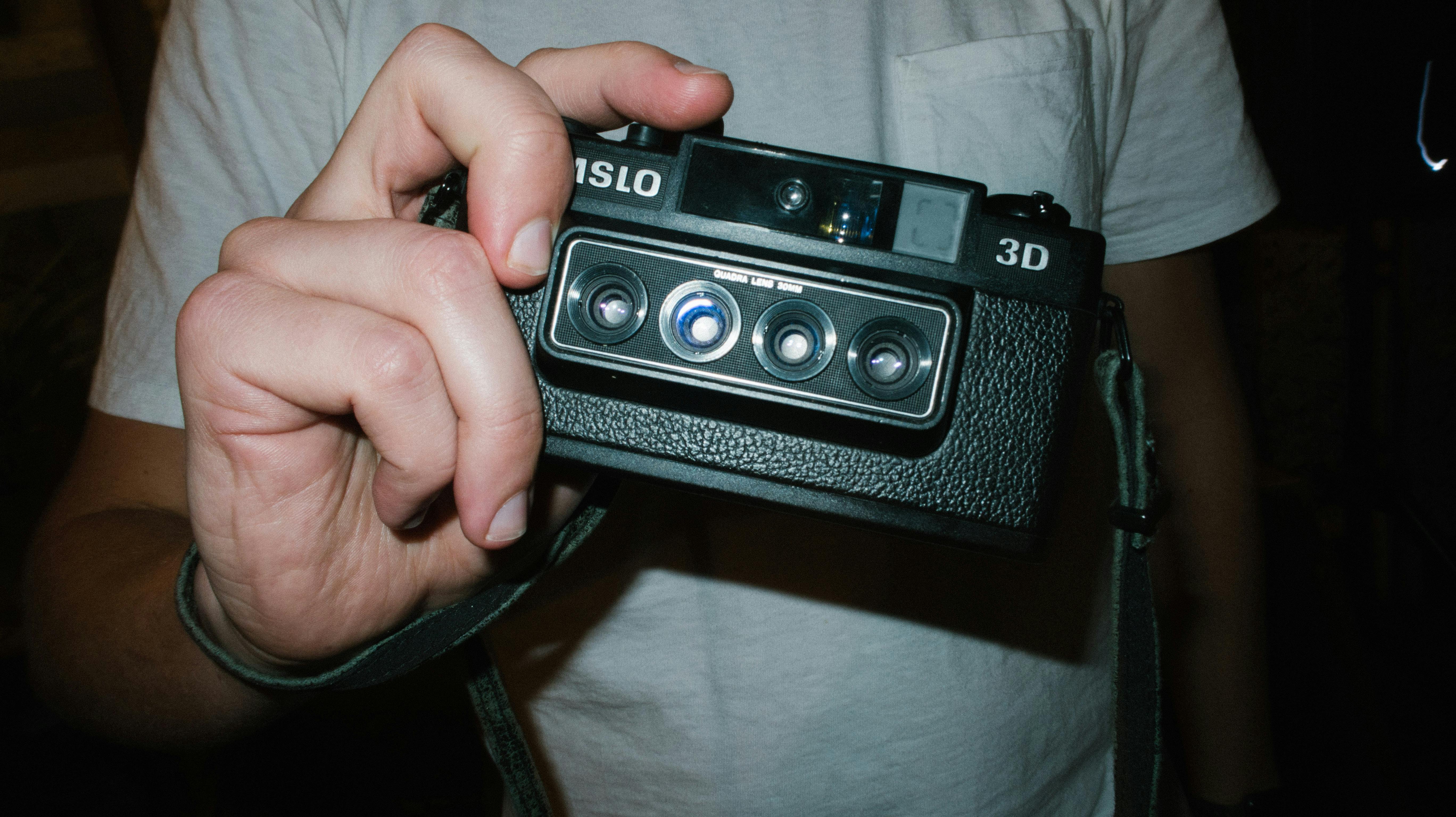 person holding black nimslo camera