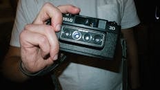 Person Holding Black Nimslo Camera