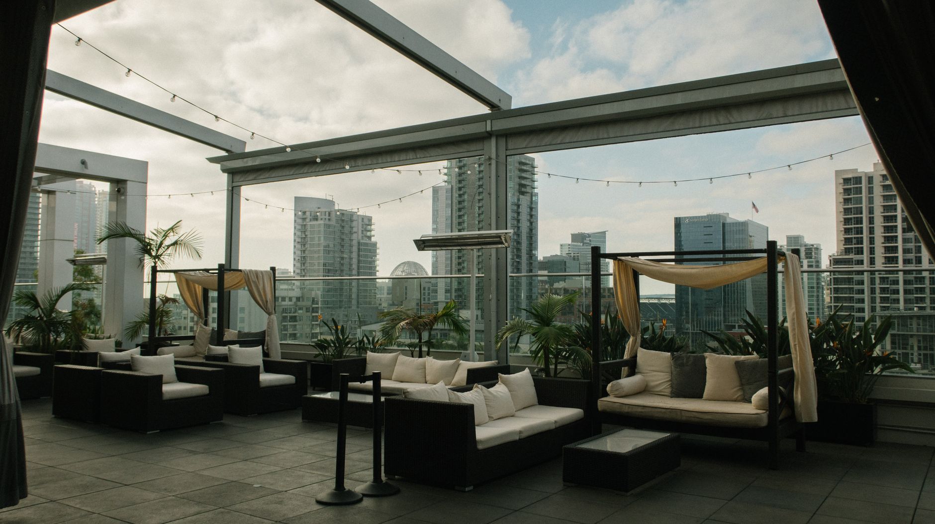 El Cockfight rooftop patio in downtown Austin with umbrellas, bar counter, and guests gathering at sunset