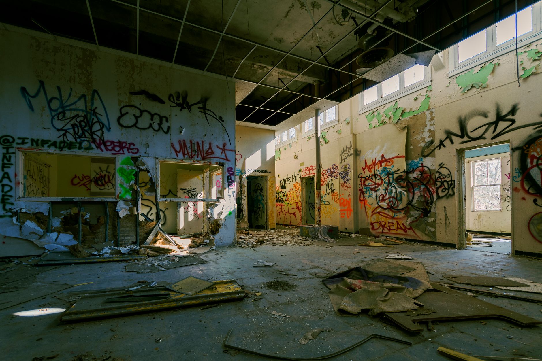 Explore the vivid street art and graffiti inside an abandoned building. Urban decay captured in daylight.