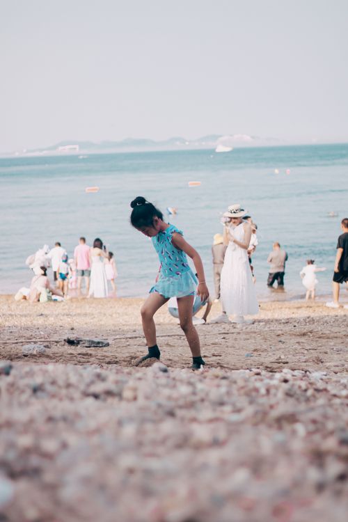 Free A lively beach scene capturing people enjoying a sunny day by the sea. Stock Photo