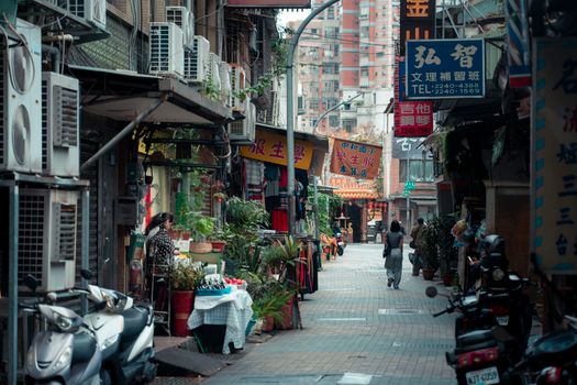 A vibrant street market in New Taipei City, showcasing local shops and pedestrians.
