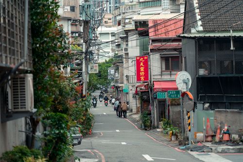Free A lively street scene in New Taipei City, Taiwan, featuring buildings, greenery, and people. Stock Photo