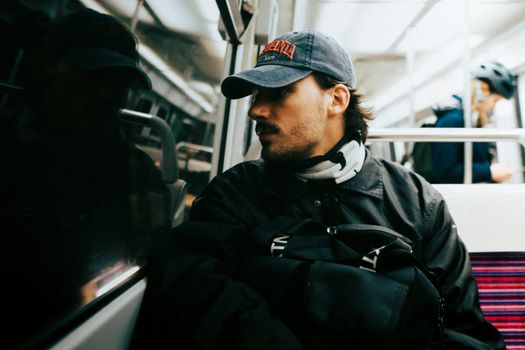 A man traveling on the Paris Metro, lost in thought during the journey.