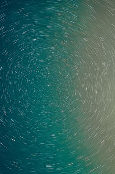 Hypnotic long exposure captures swirling star trails, creating a celestial pattern in the night sky.