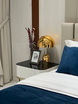 Elegant hotel bedroom in Dubai with gold lamp and blue accents.