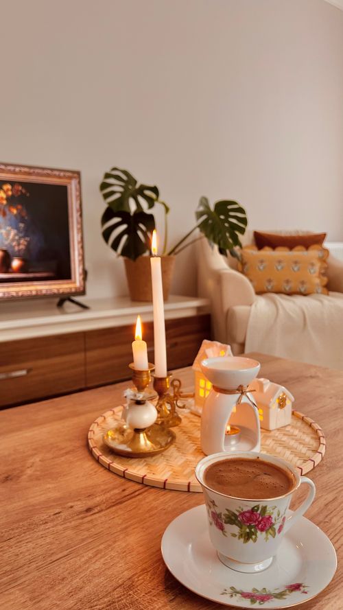 Free Warm living room setting with candles and coffee. Perfect for relaxation and cozy vibes. Stock Photo