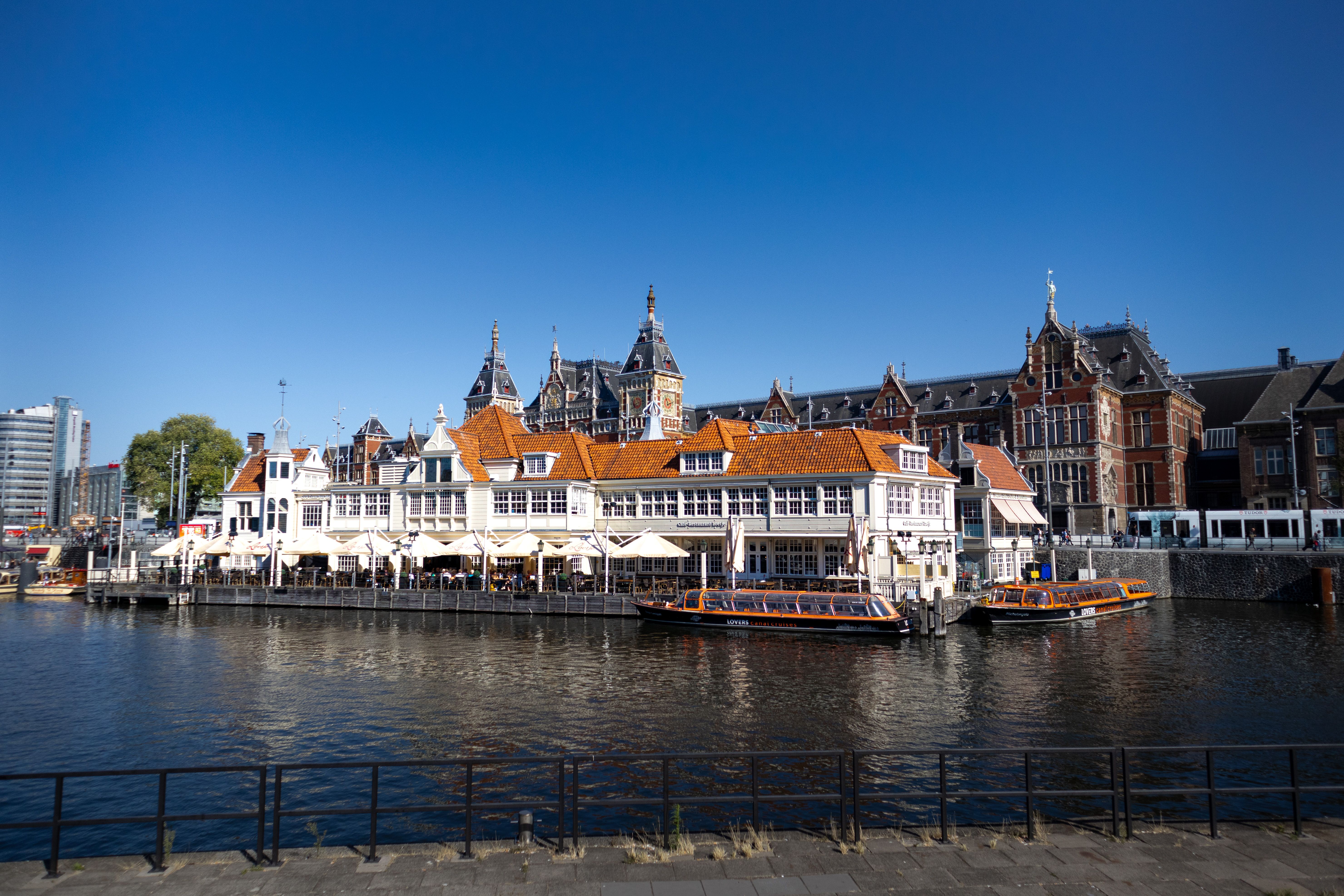 Amsterdam canal lined with gabled houses and moored boats