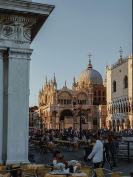 Vibrant scene of people enjoying a Venetian evening at St. Mark's Basilica, Venice.