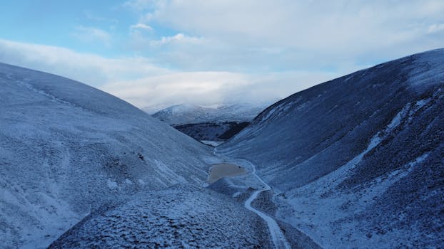 Breathtaking drone shot of snow-covered mountains in Cairngorms National Park, Scotland.