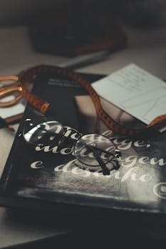 桌子上放着眼镜、书和卷尺，构成一幅复古静物画